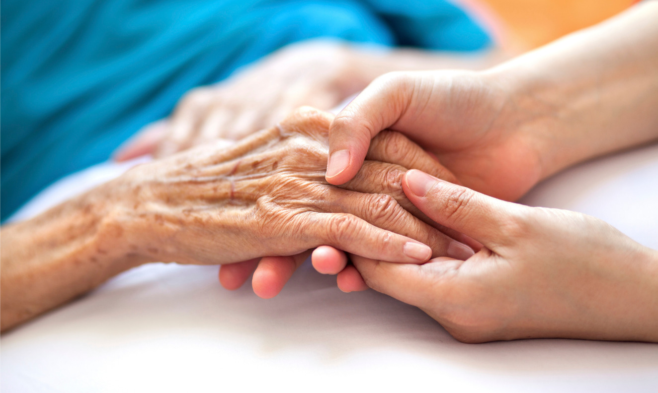 a nurse holding an elderly patient's hand