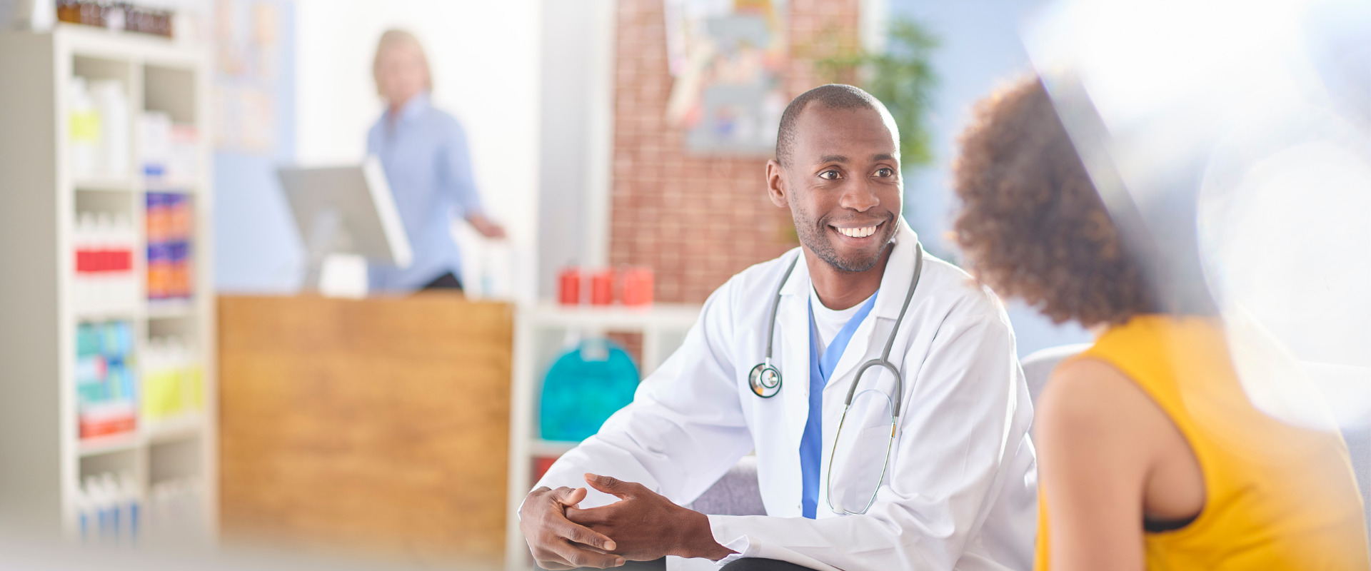 medical professional sitting and talking with a patient in his office